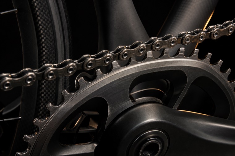 Guarnitura, corona dentata e catena di una bicicletta da corsa in luce radente